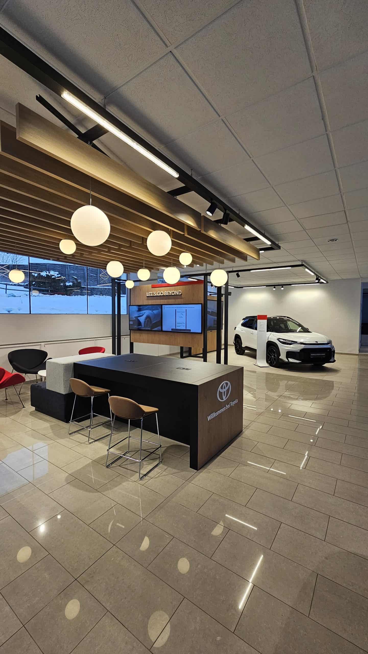 Heller Empfangsbereich im Autohaus mit Sitzgelegenheiten und moderner Dekoration.