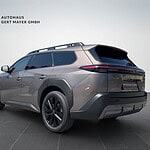 Grauer SUV im Showroom mit schwarzem Dachträger.