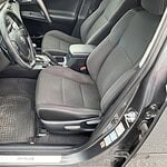 Fahrzeug-Innenraum mit schwarzen Sitzen und Lenkrad.