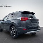 Toyota RAV4 in dunkler Farbe im Showroom.